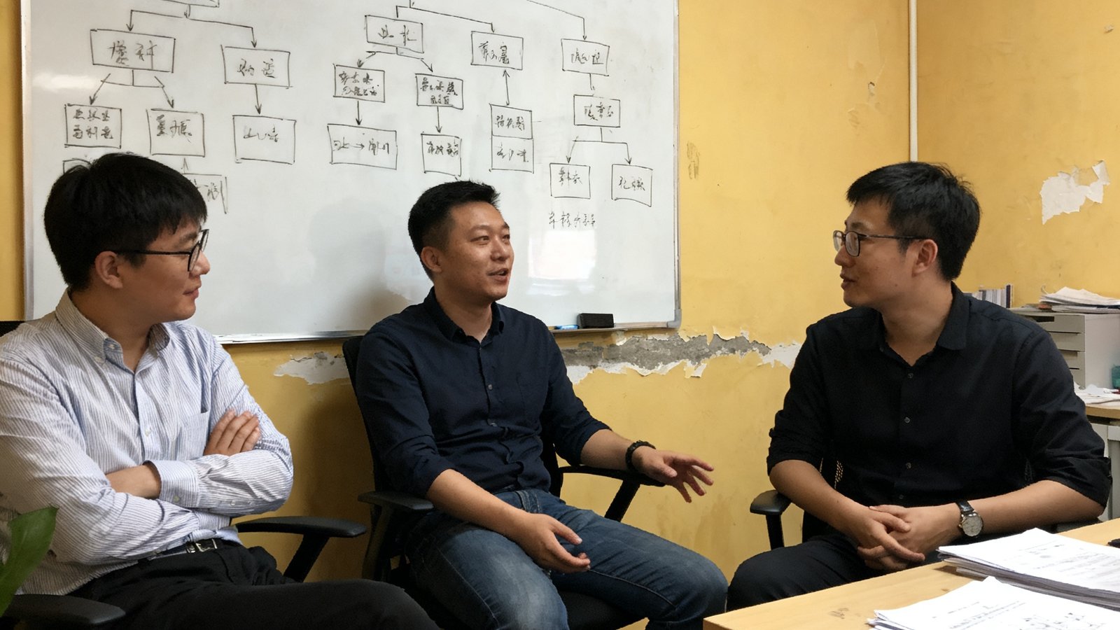 飞球直播三位创始人在2018年北京中关村创业大街的简陋办公室里讨论产品原型，白板上画满了架构图